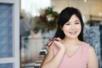 Jeune attrayant asiatique femme avec shopping sac — Photo de stock