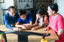 Feliz asiática familia juntos jugando juego - foto de stock