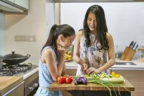 Азіатська мати і дочка готують разом на кухні — стокове фото