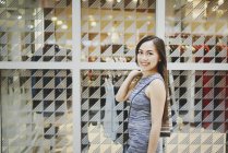 Feliz bela mulher asiática em compras com saco de compras — Fotografia de Stock