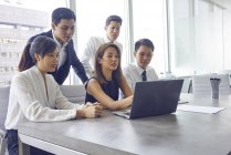 Junge asiatische Geschäftsleute arbeiten mit Laptop im modernen Büro — Stockfoto