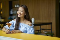 Attractive young asian woman with drink in cafe — Stock Photo