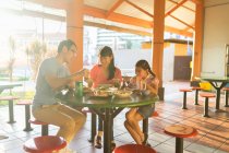 Jovem família asiática junto comendo no café — Fotografia de Stock