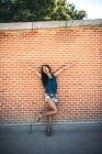 Cabello largo mujer asiática posando en pared de ladrillo - foto de stock