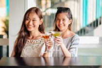 Attractive young asian women having drink — Stock Photo