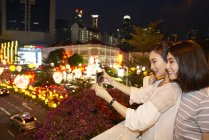 Jóvenes feliz asiático amigos pasando tiempo juntos en chino nuevo año y tomando selfie - foto de stock