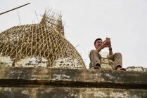Молодой человек фотографирует на пагоде Швесандо, Баган, Мьянма — стоковое фото
