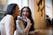 Усміхнені молоді жінки в кафе разом — стокове фото