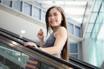 Glücklich schöne asiatische Frau beim Einkaufen mit Einkaufstasche — Stockfoto