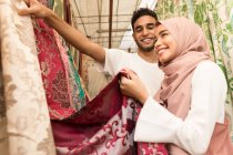 Молода мусульманська пара купує тканини в магазині — стокове фото