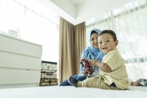 Giovane asiatica musulmana madre e bambino divertirsi a casa — Foto stock