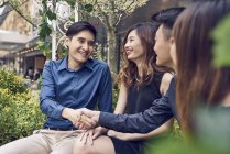 Щасливі молоді азіатські друзі роблять угоду — стокове фото