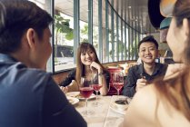 Felice giovani amici asiatici insieme in caffè — Foto stock