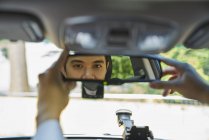 Молодий водій налаштував дзеркало заднього виду — стокове фото