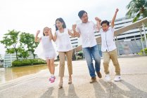 Happy asian family walking together and holding hands — Stock Photo