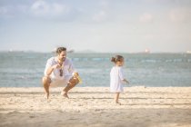 Happy young father and daughter spending time together on beach — Stock Photo