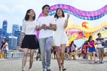 Tres jóvenes amigos asiáticos divirtiéndose en el año nuevo chino, Singapur - foto de stock