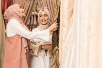 Dos chicas musulmanas en una tienda comprando cortinas - foto de stock