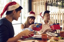 Feliz jovem asiático amigos celebrando Natal juntos no café — Fotografia de Stock