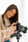 Молода жінка з довгим волоссям дивиться зображення на камеру — стокове фото
