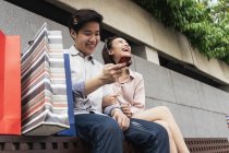 Молода азіатська пара використовує смартфон разом — стокове фото