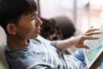 Joven adulto asiático hombre usando digital tablet en casa - foto de stock