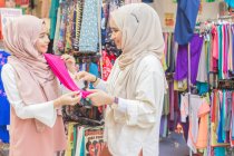 Dos chicas musulmanas en la tienda de telas - foto de stock