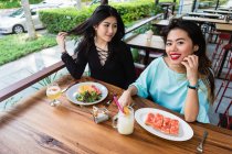 Молоді жінки їдять у кафе разом . — стокове фото