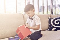 Felice giovane asiatico ragazzo celebrando il Natale e tenendo regalo — Foto stock