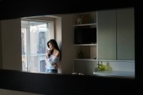 Jovem senhora chinesa bebendo café em seu apartamento de cozinha — Fotografia de Stock