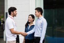 Salesperson speaking to couple on the street — Stock Photo