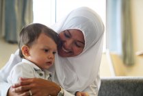 Mère à Hijab jouant avec son fils dans le salon — Photo de stock