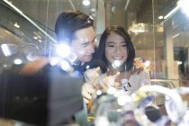 Jovem atraente asiático casal juntos olhando para jóias no shopping — Fotografia de Stock