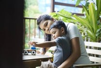Madre asiática interactuando con su hijo en casa - foto de stock