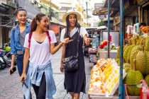 Девушки развлекаются покупками уличной еды в Чайнатауне, Таиланд — стоковое фото