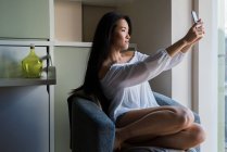 Junge Chinesin und schöne Frau macht ein Selfie in ihrem Haus — Stockfoto