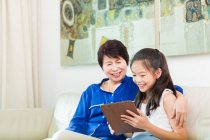 Grandmother and grandchild using a tablet together. — Stock Photo