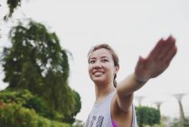 Jovem asiático desportivo mulher fazendo alongamento ao ar livre — Fotografia de Stock