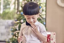 Piccolo asiatico ragazzo mangiare biscotto a natale — Foto stock