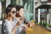 Young attractive asian couple having drink in cafe — Stock Photo