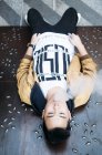 Giovane uomo asiatico con vaporizzatore sdraiato sul pavimento — Foto stock