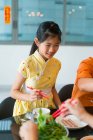 Little asian girl with family eating together at table at chinese new year — Stock Photo