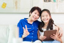 Grandmother and granddaughter using digital tablet at home — Stock Photo