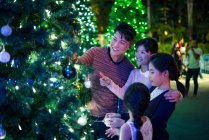 Happy asian family spending time together in amusement park at christmas — Stock Photo
