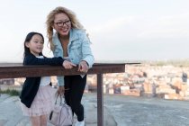Jovem mãe feliz com sua filha apreciando a vista da cidade — Fotografia de Stock