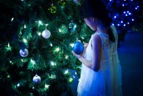 Щаслива азіатська дівчина грає з бульбашкою біля ялинки в парку розваг на Різдво — стокове фото