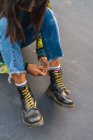 Молода азіатська жінка зв'язує шнурки, крупним планом — стокове фото