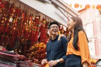 Joven asiático pareja celebrando chino nuevo año juntos en chinatown - foto de stock