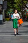 Junge Frau zu Fuß und beim Einkaufen auf der Obstgartenstraße in Singapore. — Stockfoto