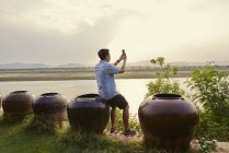 Jeune homme prenant une photo de la rivière Irrawady . — Photo de stock